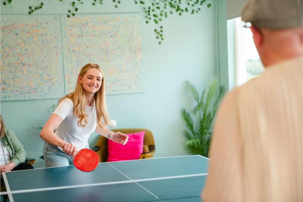 Kvinne og mann spiller bordtennis sammen