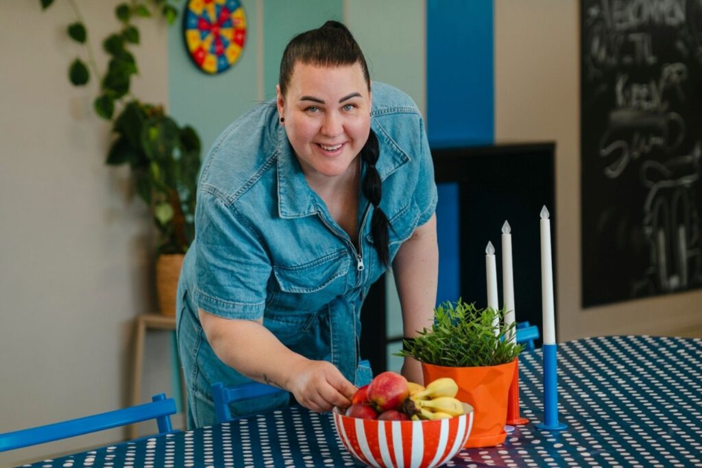 Kvinne plukker en frukt fra et fruktfat
