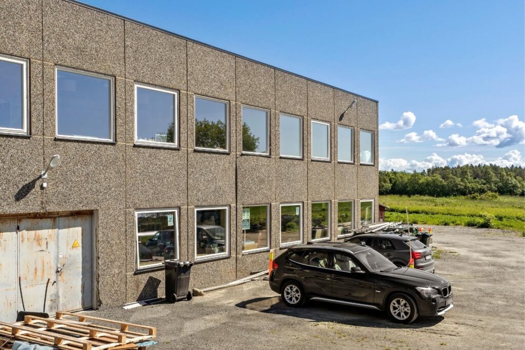 Kubelignende bygg med parkeringsplass utenfor.