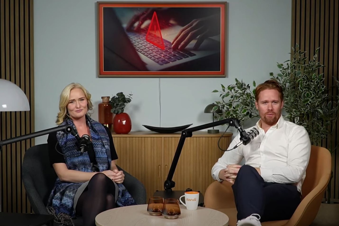 Kvinne og mann i podcast-studio