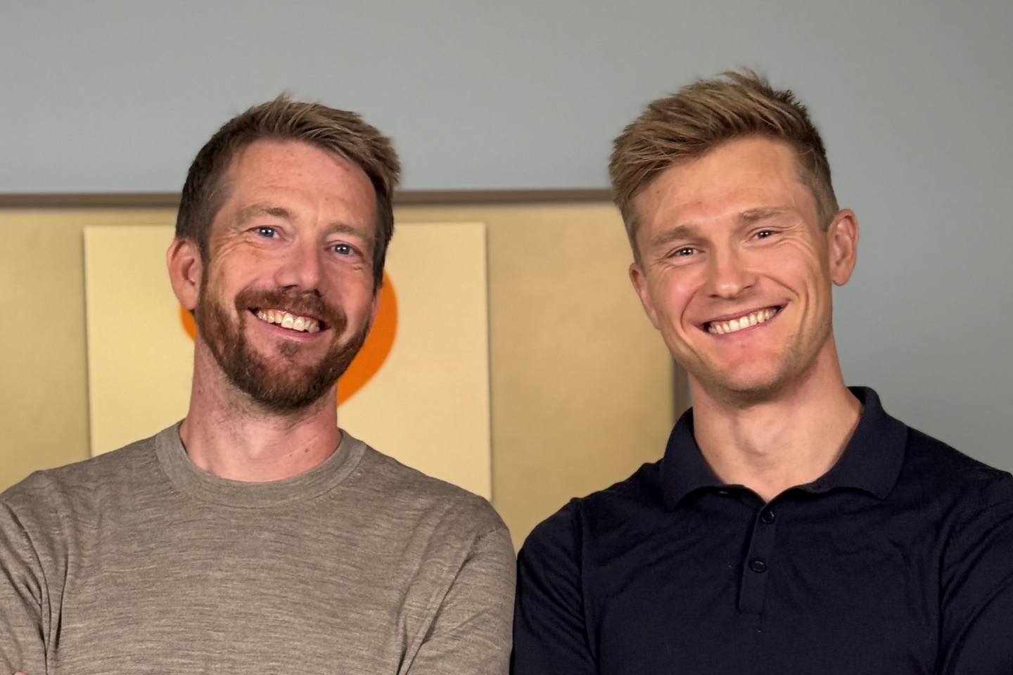 To menn som smiler og ser i kameraet