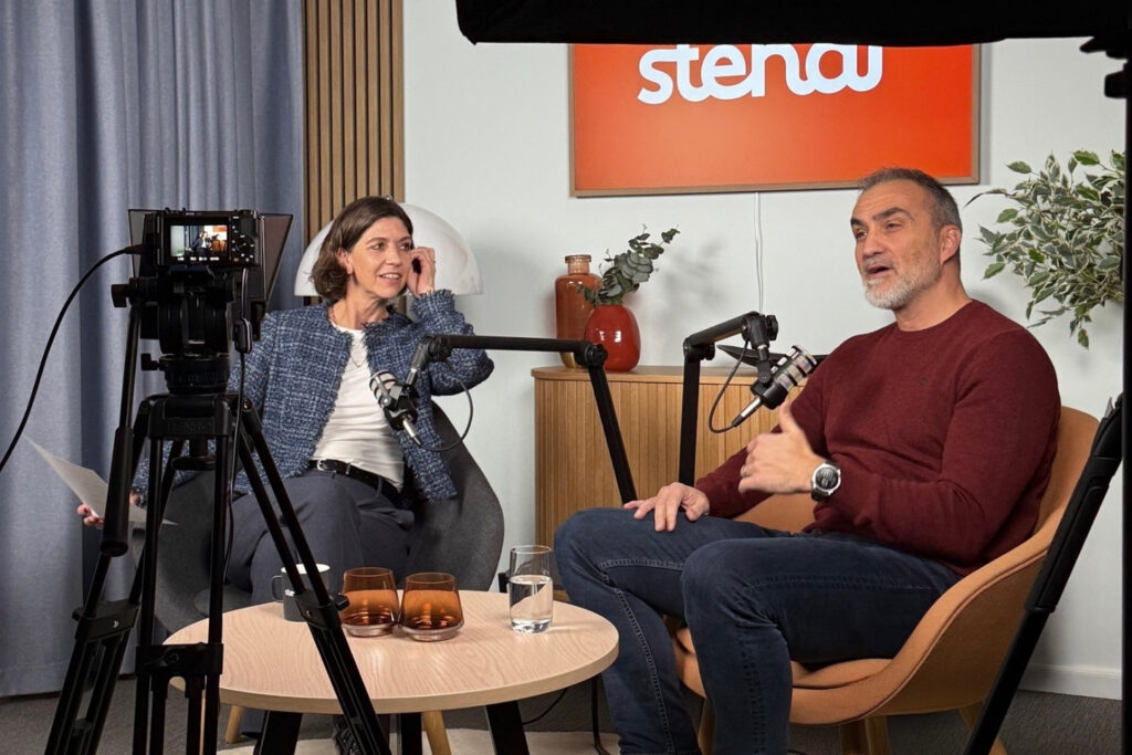 En mann og en kvinne har en samtale i et studio  med mikrofoner